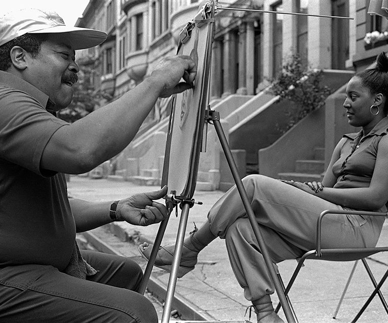 CCF CETA artist Selvin Goldbourne drawing portraits at a Harlem block party; Photo by Blaise Tobia for the CCF CETA Arts Project,1978. © Blaise Tobia, 2023.